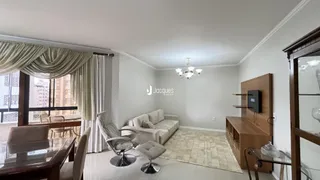 Sala de estar com sofá e grandes janelas na residência.