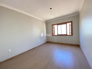 Sala de estar com piso de madeira clara e janela grande.