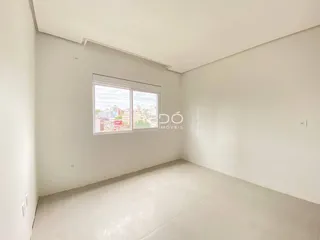Ambiente interno de uma sala de estar com grande janela.