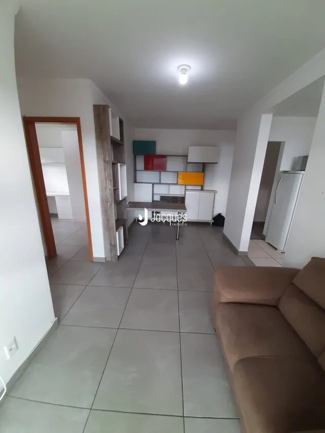 Hall de entrada com piso de cerâmica e estantes de madeira.