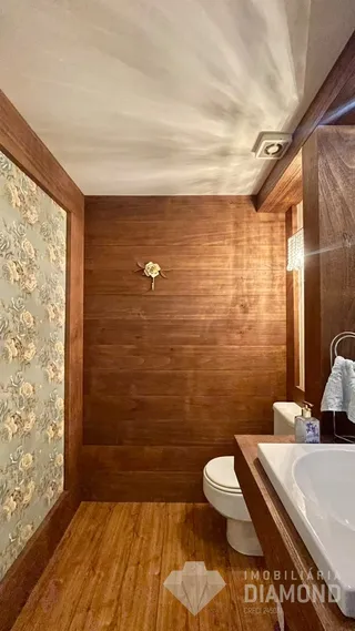 Hall de entrada com revestimento de madeira e papel de parede.