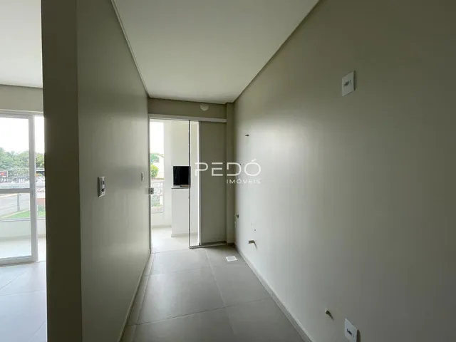 Corredor interno de um imóvel com paredes claras e piso claro.