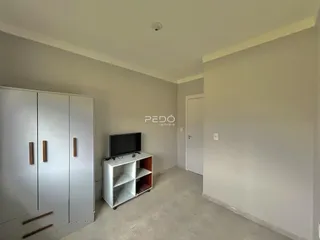 Ambiente interno de uma sala com armários e televisão em um imóvel.