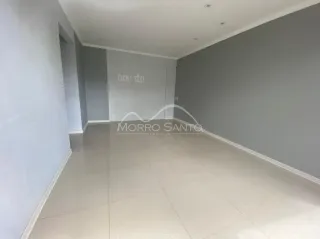 Hall de corredor com paredes cinzas e piso claro.