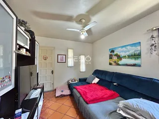 Sala de estar com sofá azul e cama em um imóvel no Brasil.