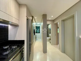 Interior de uma cozinha moderna com armários e piso claro.