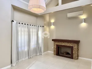 Ambiente interno com paredes claras e uma lareira de pedra.