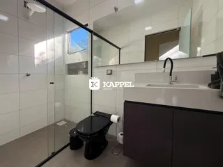 Banheiro com box de vidro e louças sanitárias.