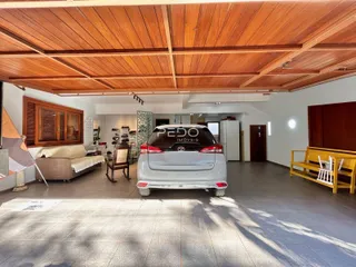 Ambiente interno de uma sala com teto de madeira e móveis.