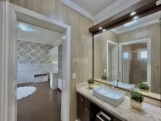 Interior de um banheiro moderno com bancada e banheira brancas.