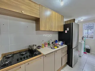 Cozinha moderna com armários de madeira e eletrodomésticos pretos.