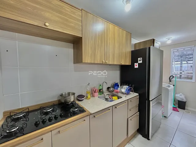 Cozinha moderna com armários de madeira e eletrodomésticos pretos.