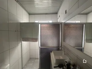 Parede interna com revestimento cerâmico branco em uma residência.