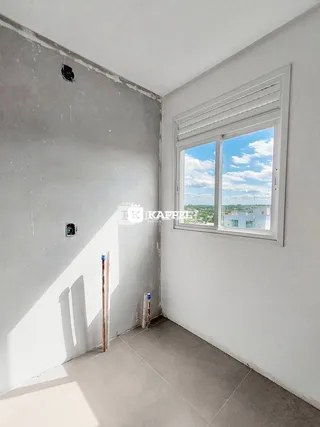 Foto de um cômodo com paredes em fase de acabamento e uma janela com vista para a paisagem.