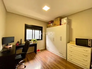 Quarto com armários embutidos e escrivaninha de madeira em um imóvel no Brasil.