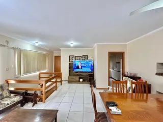 Sala de estar com piso de cerâmica e móveis de madeira clara.