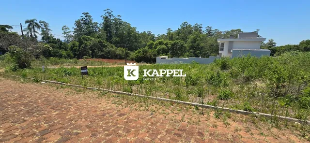 Vista externa de uma residência branca em Lajeado, Brasil, com vegetação ao redor.