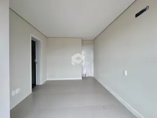 Hall de entrada com paredes brancas e piso claro.