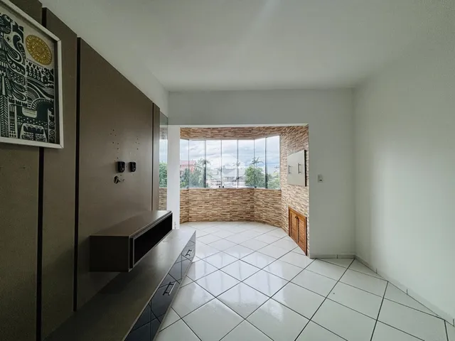 Sala de estar com vista para o exterior e parede de tijolos aparentes.
