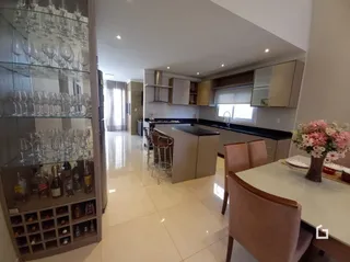 Cozinha com armários e bancadas em um imóvel no Brasil.