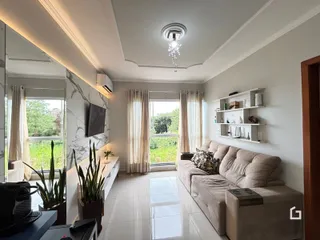 Sala de estar iluminada com vista para o jardim externo.