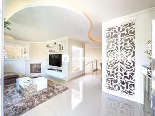 Sala de estar moderna com lareira e decoração clara em um imóvel no Brasil.