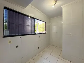 Interior de um corredor com paredes brancas e piso de cerâmica.