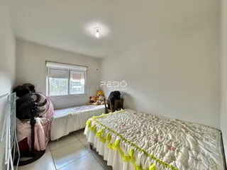 Quarto com duas camas de solteiro e janela.