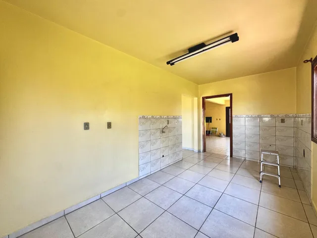 Interior com paredes amarelas e piso de cerâmica.