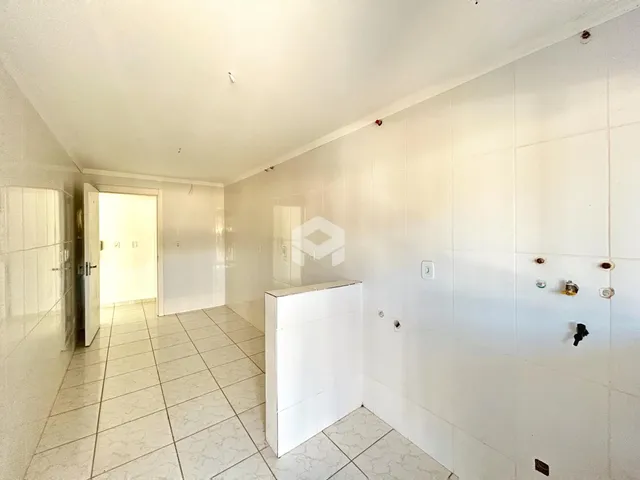 Corredor interno de uma residência com piso de cerâmica clara.