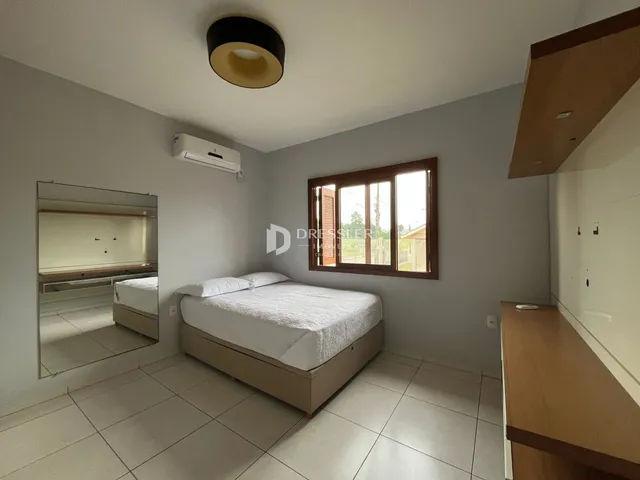 Quarto com cama e janela de madeira.