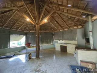 Ambiente interno com estrutura de teto de madeira aparente.