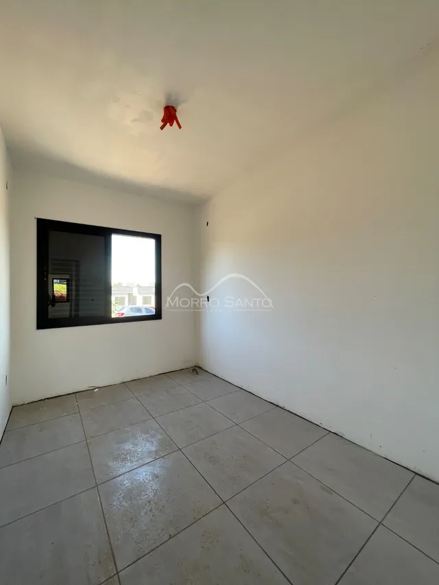 Ambiente interno com paredes brancas e piso de cerâmica.