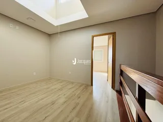 Ambiente interno de uma sala com piso de madeira clara.