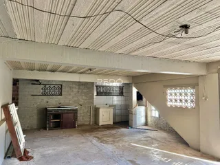 Foto de um espaço interno com paredes de tijolo aparente e teto de concreto.