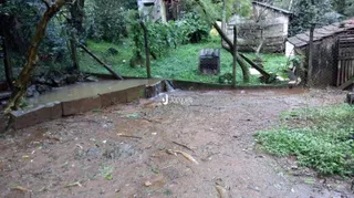 Vista da propriedade mostrando um riacho e vegetação ao redor.