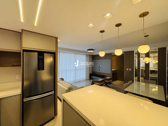 Interior de uma sala de estar e cozinha moderna com armários em madeira.