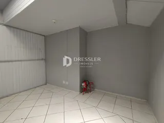 Foto de um cômodo interno com piso de cerâmica e paredes brancas.