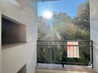Vista da varanda com árvores ao fundo.