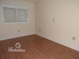 Ambiente interno de uma sala com piso de madeira clara.
