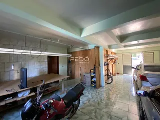 Interior de uma sala ampla com piso de cerâmica e portas de madeira.