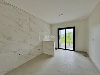 Interior de um ambiente com revestimento de mármore branco e piso claro.