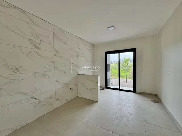 Interior de um ambiente com revestimento de mármore branco e piso claro.