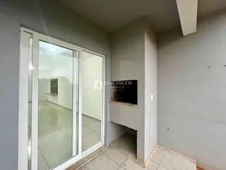 Vista interna de um corredor com porta de vidro em um imóvel no Brasil.