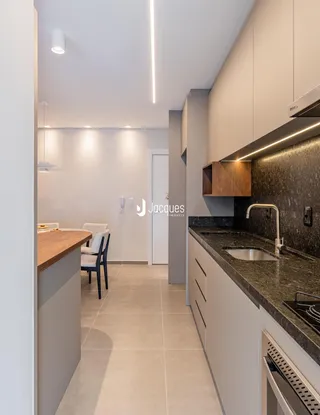 Vista de uma cozinha moderna e sala de jantar em um apartamento.