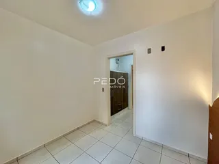 Hall de entrada com piso de cerâmica clara e paredes brancas.