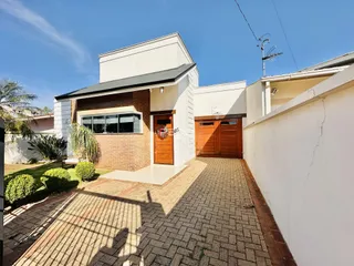 Fachada externa de uma casa em Lajeado, Brasil, com garagem de madeira e alvenaria.