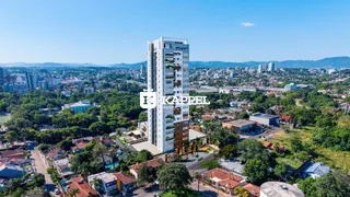 Uma vista aérea de um edifício residencial alto em Lajeado, Brasil, cercado por vegetação.