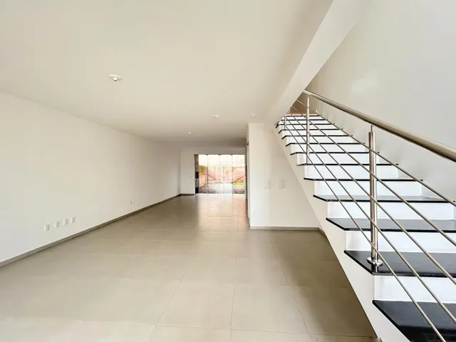Hall de entrada longo com piso de cerâmica e escadaria.