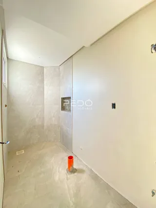 Hall de corredor interno com paredes claras e piso de pedra na propriedade.